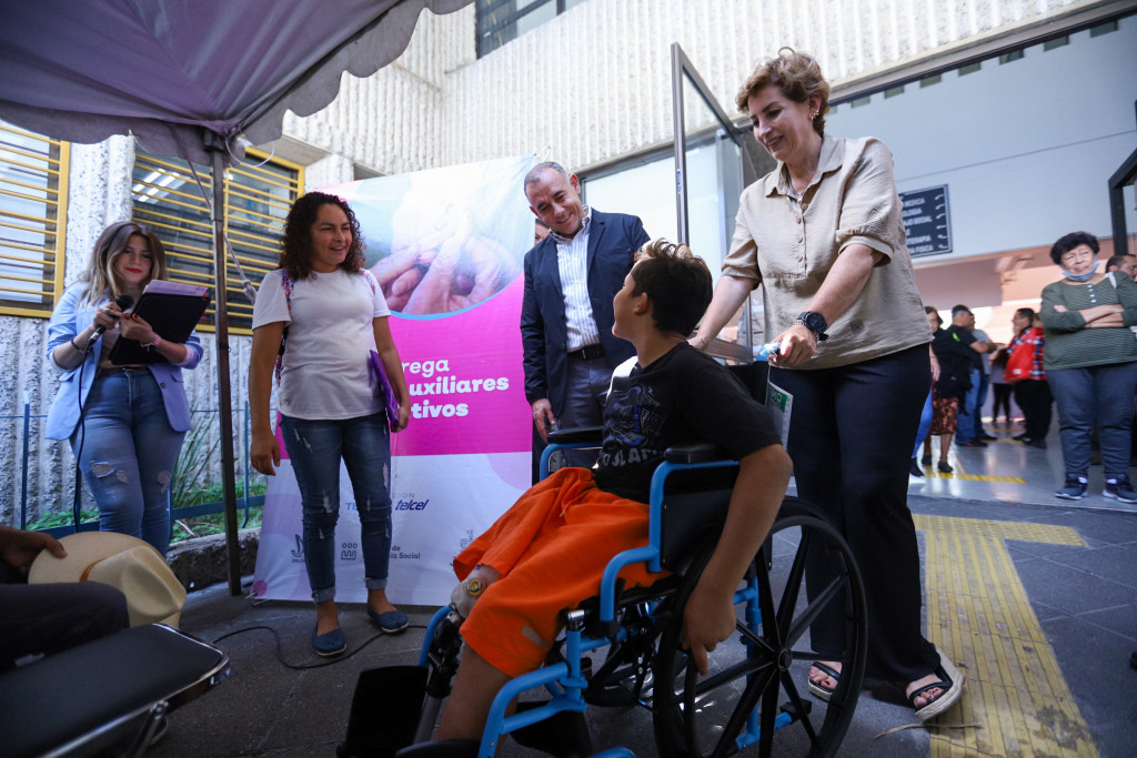 Autoridades saludan a un niño que trae su silla de ruedas