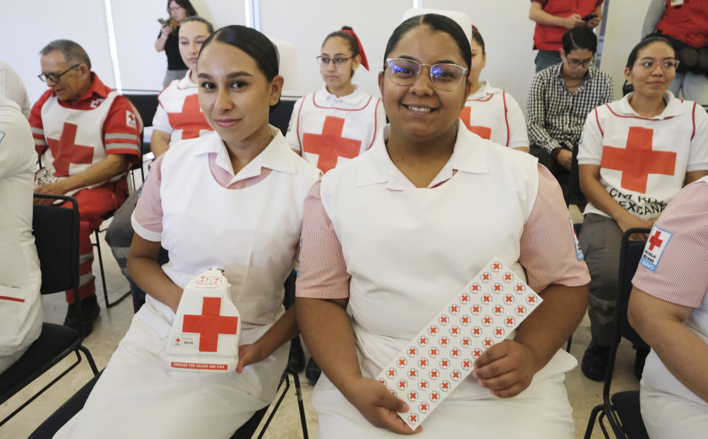 2 Enfermeras sostienen bote de colecta y stickers
