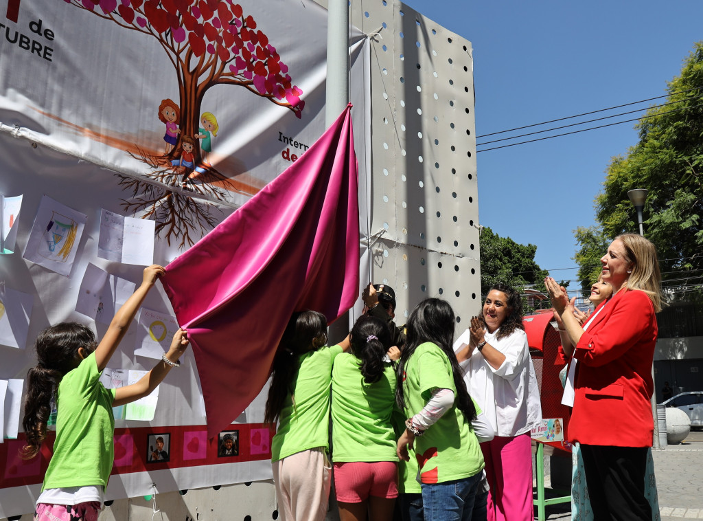 Autoridades y niñas izan la bandera de la PPPNNA