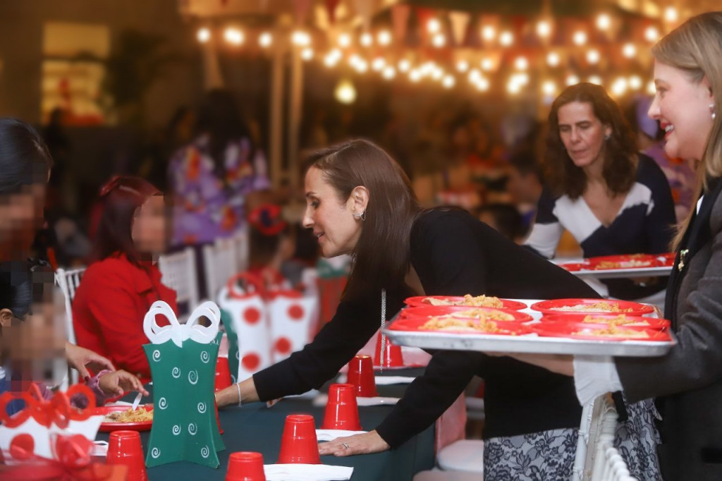 Sra Maye junto a Joana Santillán y Paola Lazo repartes la cena navideña a residentes de Cien Corazones