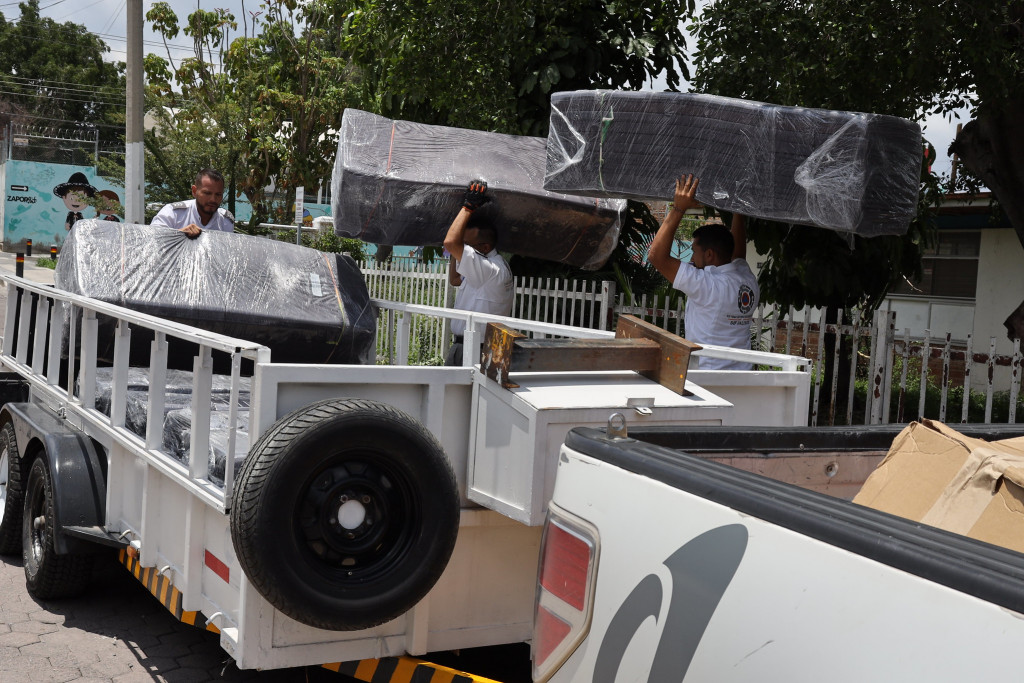 Personal de Protección Civil cargan camionetas con colchonetas