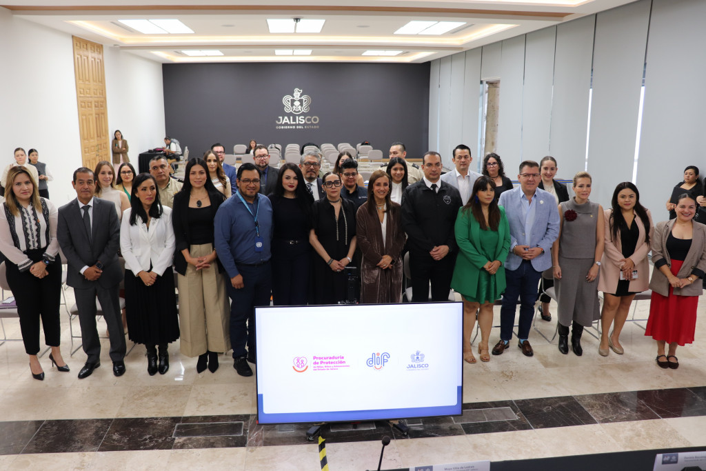 Foto oficial de autoridades asistentes, al frente Maye Villa y Diana Vargas al fondo el escudo de gobierno de Jalisco