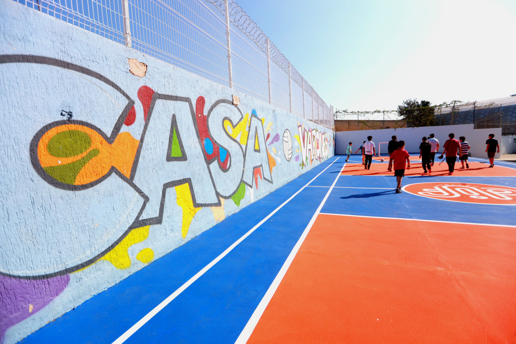 Niños al fondo jugando sobre la cancha rehabilitada