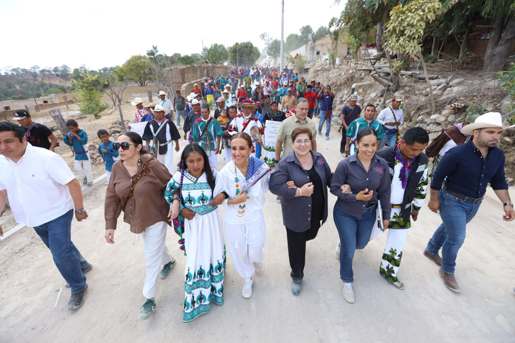 Autoridades encabezadas por Maye Villa y Diana Vargas caminan por las calles de Ocota de la Sierra en Mezquitic, detras de ellas caminan los pobladores