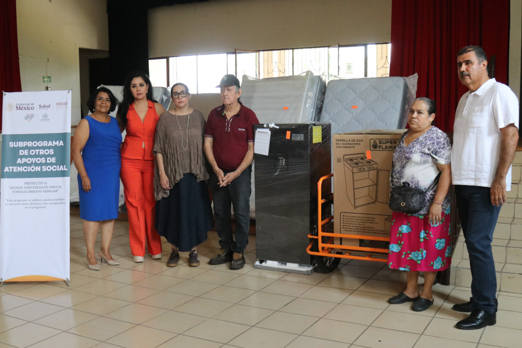 Autoridades junto a familia beneficiada con apoyos